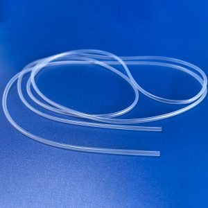 Flexible, small-diameter silicone tubing coiled on a blue surface